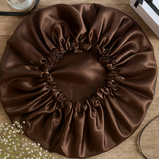 Brown satin bonnet on a wooden surface with a blurred background